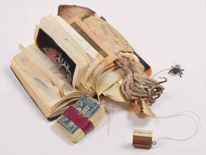 Het tripbook van Tjeerd Deelstra met aandenkens van Fluxus-kunstenaars zoals haren, tekeningetjes en een gedroogde inktvis.