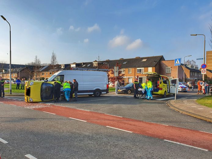 De gele auto belandde na de botsing op z'n kant.