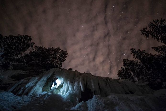 Een Zwitserse ijsklimmer beklimt 's nachts de ijswand in La Lecherette. Foto Anthony Anex
