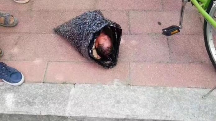 Een foto die circuleert op Chinese sociale media toont het meisje in de plastic zakken waarin de moeder haar verpakt had.