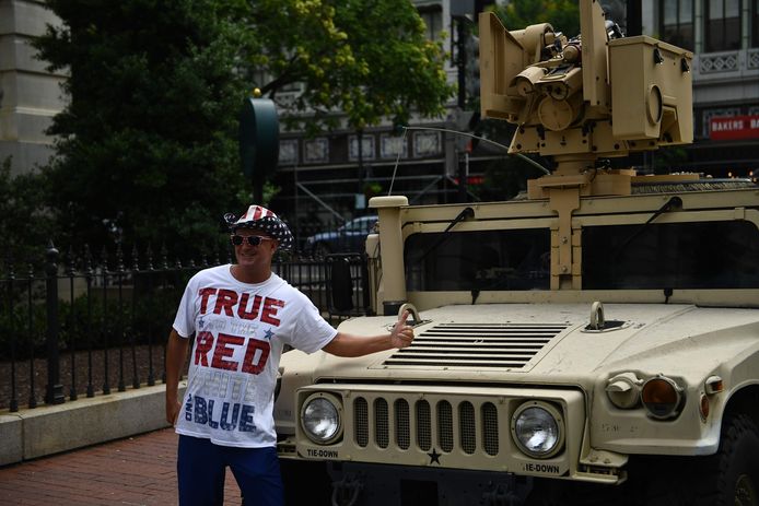 Een Trump-aanhanger voor een geparkeerde Humvee.