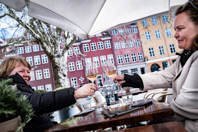 Vrouwen genieten van een glaasje wijn op een terras in Kopenhagen.