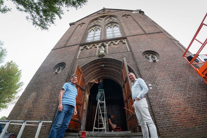Adrie Kuijstermans (r) met koster José Frijters voor de toegangsdeuren van de voormalige Martelaren van Gorcumkerk te Stampersgat. De schilders zijn bezig.