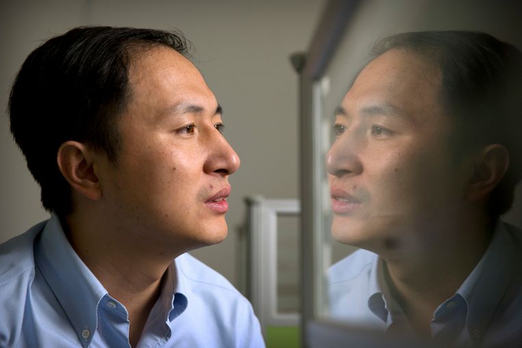 He Jiankui ziet zijn spiegelbeeld in het glas van zijn laboratorium in Shenzhen. Hij claimde de eerste genetisch gemanipuleerde baby te hebben gemaakt.  

 Beeld AP
