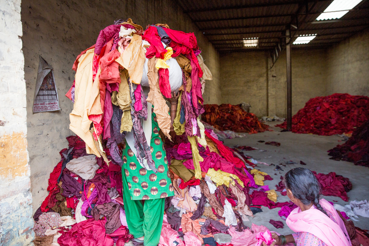 Een vrouw sorteert kleding in de Indiase stad Panipat. Ze maken er kleden en kledingstukken van. Beeld RUHANI KAUR