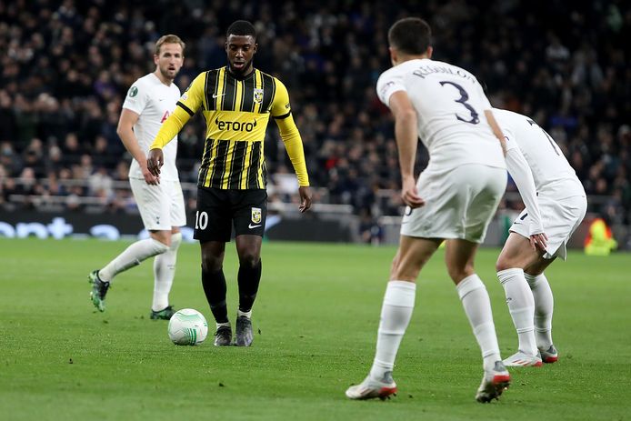 Riechedly Bazoer drukt namens Vitesse Tottenham Hotspur in de verdediging in de Conference League. Sergio Reguilon (3) en Heung-min Son wachten af, Harry Kane kijkt op  de achtergrond toe.