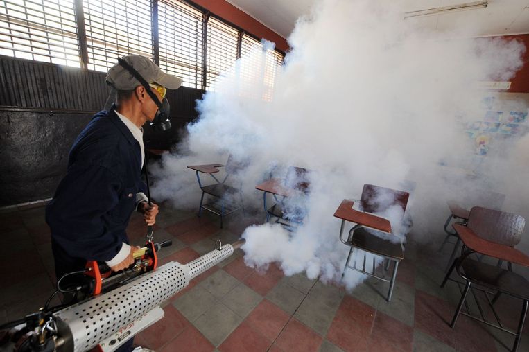 Een man ontsmet een klaslokaal in Tegucigalpa, Honduras. Beeld anp