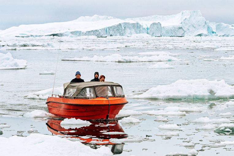 Een vissersbootje navigeert tussen de ijsschotsen voor de kust van Groenland. Beeld NurPhoto via Getty Images