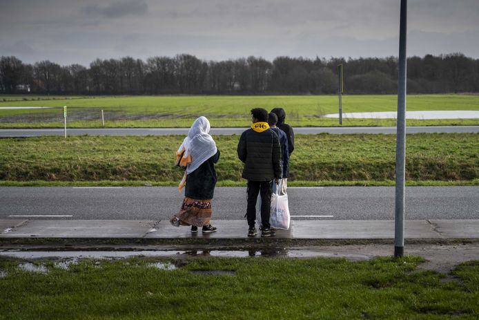 Asielzoekers bij de bushalte bij het aanmeldcenrum Ter Apel van het COA.