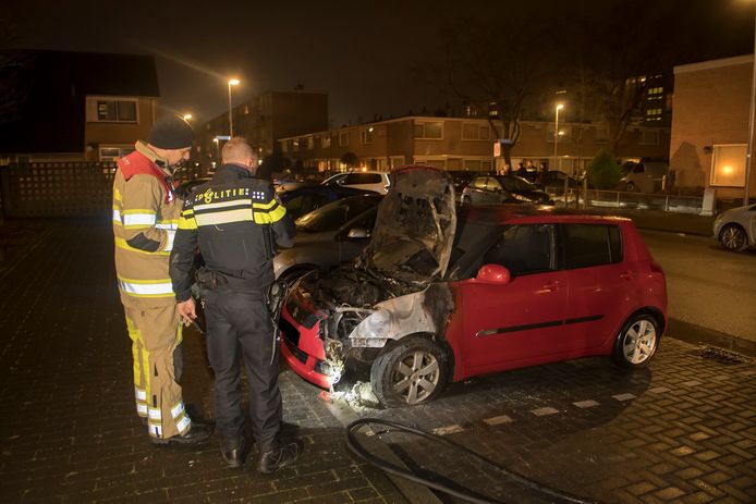 Autobrand in de Utrechtse wijk Kanaleneiland. Brandweermannen nemen de schade op.