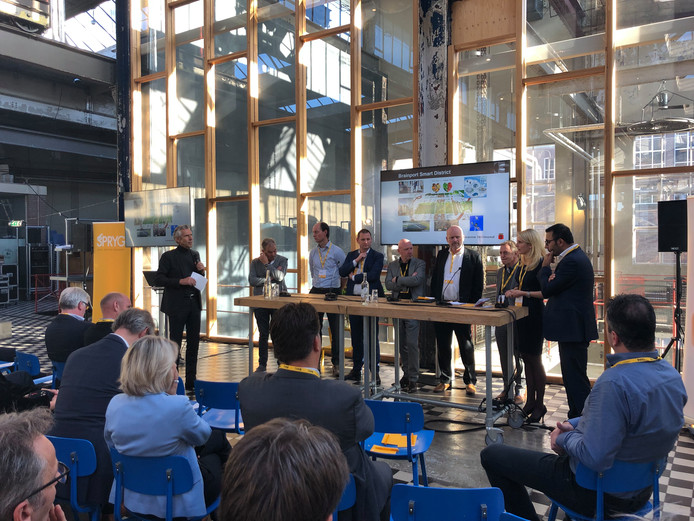 Een beeld van het congres Woningbouw Brabant 2018 van Sprygg in Radio Royaal op Strijp-S. Helemaal rechts aan de tafel wethouder Yasin Torunoglu van Eindhoven met naast hem wethouder Gaby van den Waardenburg van Helmond. Vierde van rechts Theo van Kroonenburg, directeur van corporatie Sint Trudo.