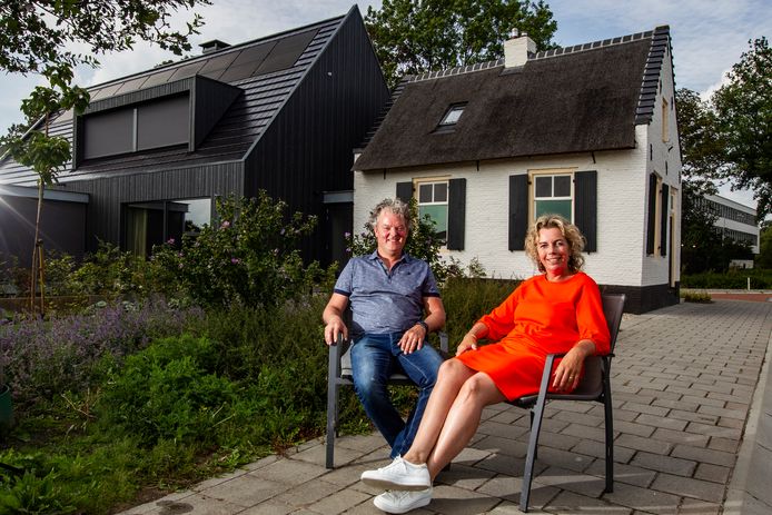 Frank en Marieke Elders met op de achtergrond het oudste tolhuisje van Raalte, waar ze hun nieuwbouwwoning aan hebben gebouwd.