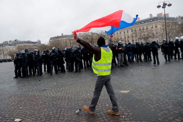 Een demonstrant zwaait met de Franse vlag.
