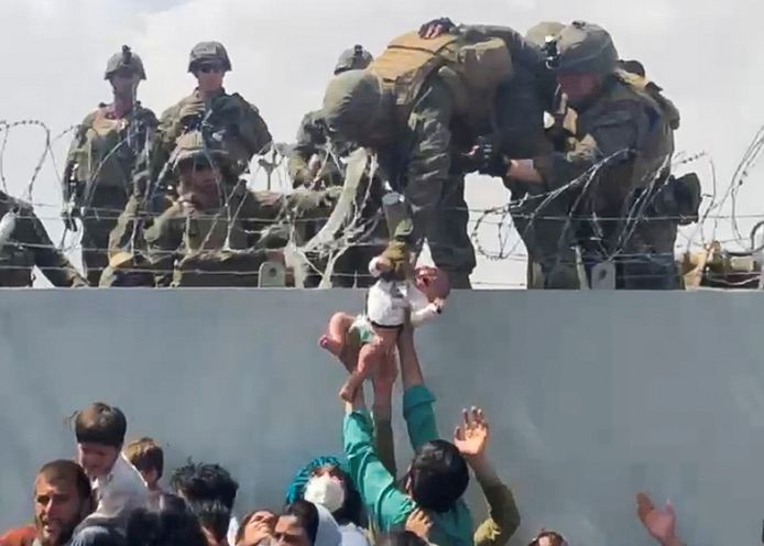 Dans le chaos qui règne autour de l'aéroport de Kaboul, un bébé en pleurs est remis aux soldats américains.
