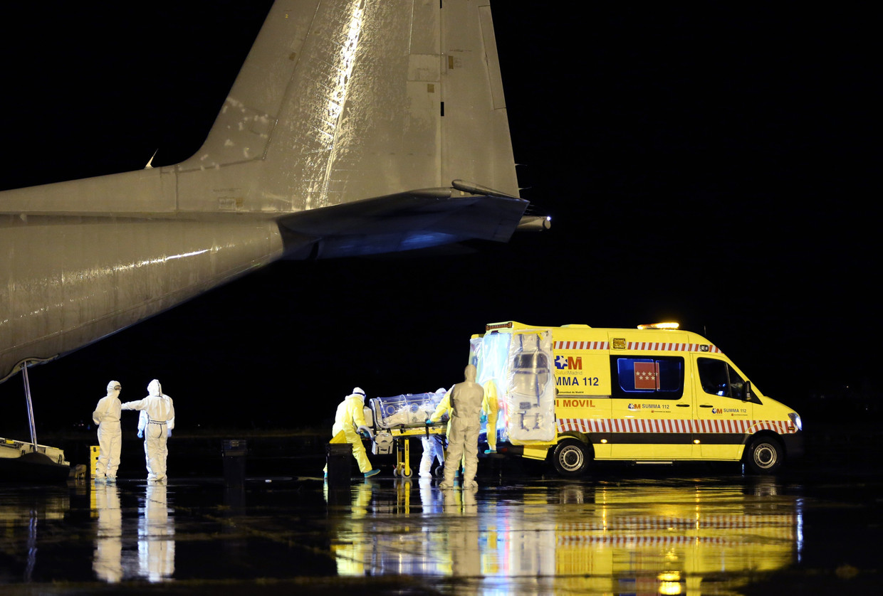 Een met ebola besmette Spanjaard wordt vanuit een vliegtuig naar een ambulance overgebracht op een militair vliegveld in Madrid. Beeld getty
