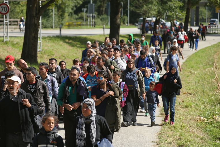 Vluchtelingen proberen vanuit Salzburg te voet de grens met Duitsland te bereiken nu er geen treinen meer rijden. Beeld getty
