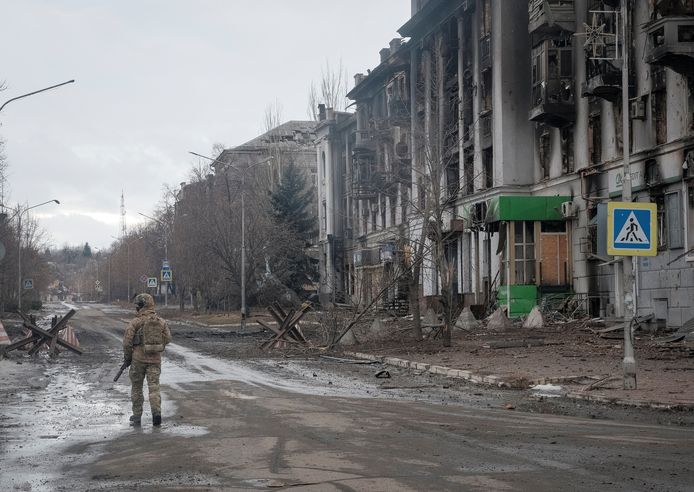 Een Oekraïense soldaat patrouilleert door een lege straat in Bachmoet, oostelijke Oekraïense stad aan de frontlijn.