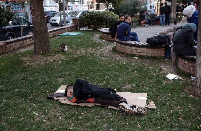 Een migrant slaapt in een parkje in een van de wijken van Istanboel.
