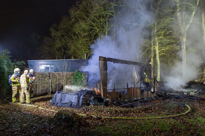 Brandweerlieden bekijken de rokende puinhoop van het gastenverblijf dat in vlammen is opgegaan. Nummer vijf in korte tijd op de Koekamp in Epe.