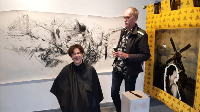 Ron Jagers, exposeert en knipt uit protest tegen lockdown beeldende kunst. Klant Fons maakte het doek 'Fijne chaos en een gelukkig nieuwjaar' op de achterwand.