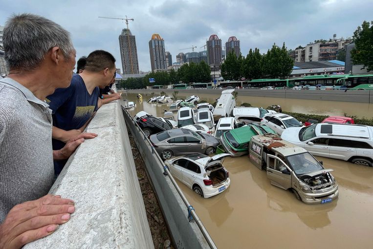 Inwoners van Zhengzou overschouwen de ravage die de storm heeft achtergelaten.  Beeld AFP