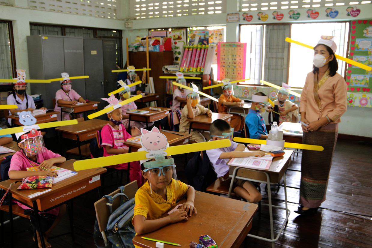 Een klas in Thailand heeft speciale hoedjes gemaakt om aan te geven hoeveel afstand moet worden gehouden.  Beeld AP
