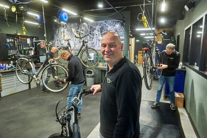 Michel van de Wetering in de werkplaats van zijn fietsenzaak in Heesch. Onafgebroken sleutelen er drie monteurs aan fietsen. De fietsenbranche heeft er een tekort aan.