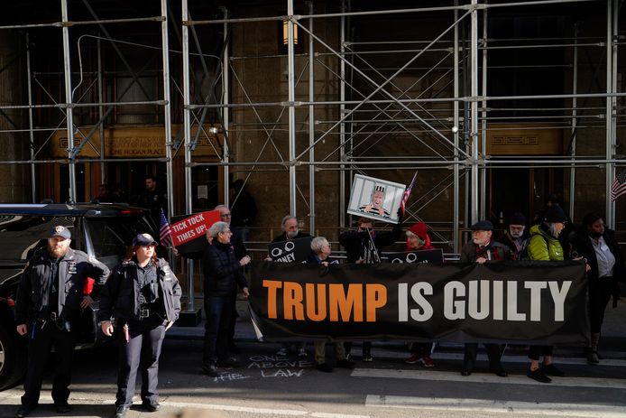 Mensen protesteren voor het kantoor van het openbaar ministerie in New York, dat zal beslissen over een mogelijk arrestatiebevel tegen de voormalige president Donald Trump.