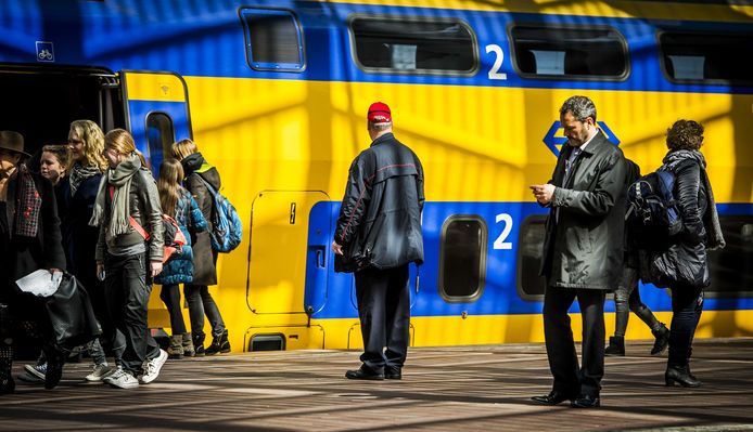 Een conducteur staat bij een NS-trein op station Rotterdam Centraal.