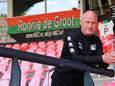 Assistent-trainer Ron de Groot poseert voor zijn eigen spandoek in De Goffert.