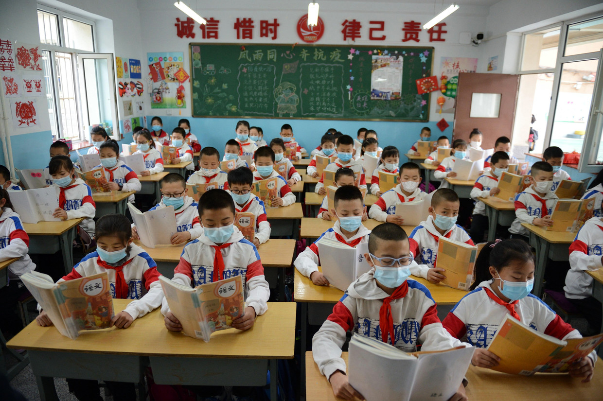 Leerlingen uit Binnen-Mongolië dragen mondkapjes in de klas. Beeld Getty