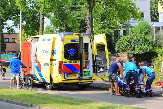 Hulpverleners ontfermen zich over de gewonde fietser.