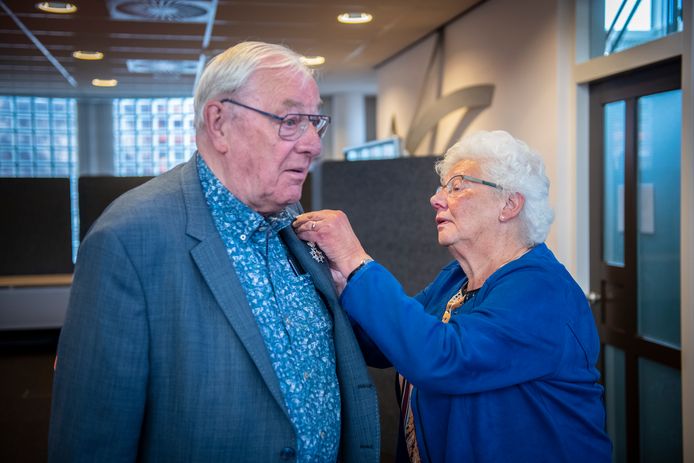 Rien Stek krijgt een lintje opgespeld van zijn vrouw.