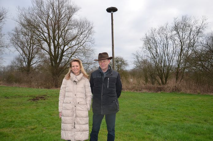 Initiatiefnemer Johan Allard uit Okegem met schepen Katie Coppens aan de ooievaarspaal werd geplaatst op het domein van kaatsvereniging de Amusanten aan de Fonteinstraat.