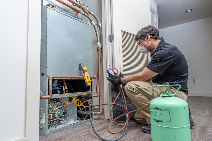 Een installateur werkt aan een warmtepomp.