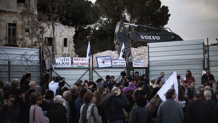 Demonstranten protesteren in Jeruzalem bij een gesloopt hotel. Beeld afp