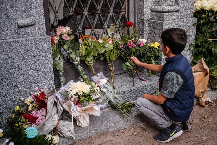 Een jongen brengt een bloem naar het graf van Aznavour in het Montfort l'Amaury kerkhof in West-Parijs.