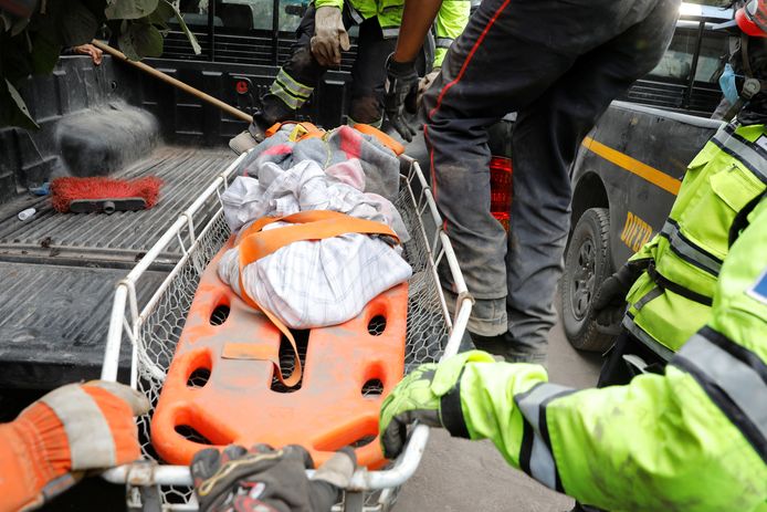 Een stretcher met stoffelijke resten van een slachtoffer van de vulkaan.