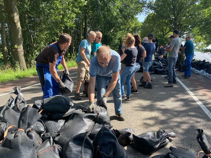 Inwoners van Arcen proberen te redden wat er te redden valt en leggen op een weg over twee kilometer extra zandzakken.