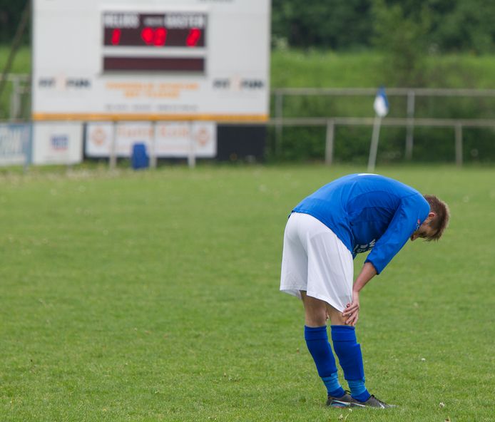 Een voetballer van Helios uit Deventer baalt na een verloren wedstrijd.