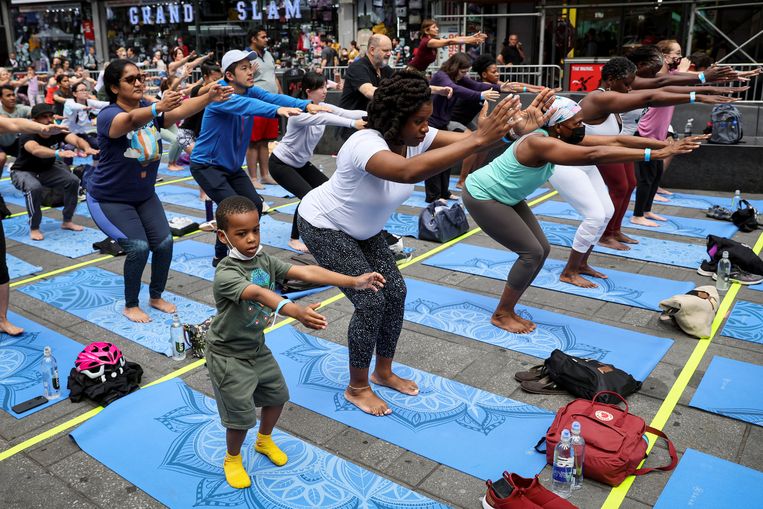 Yogabeoefenaars vieren de zomerzonnewende op Times Square in New York. Beeld REUTERS
