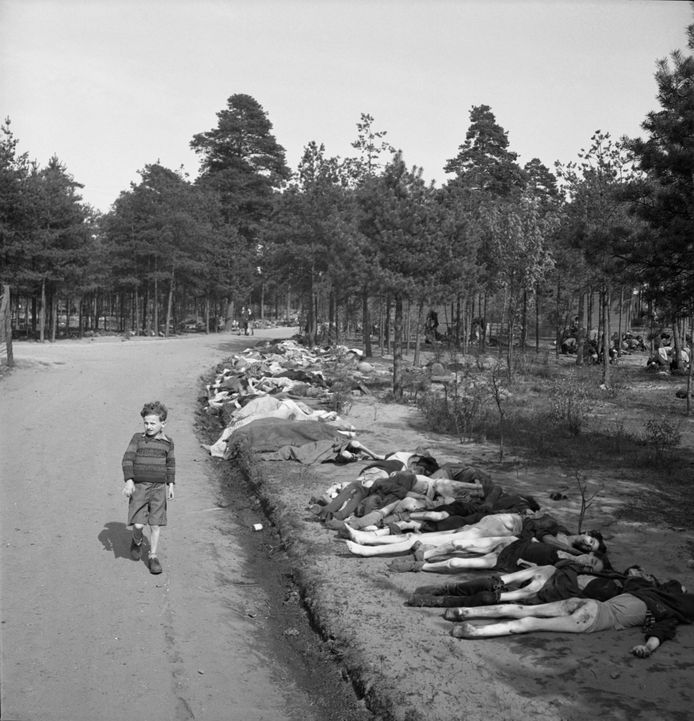 A little boy (not Louk de Liever) walks past the bodies of hundreds of dead prisoners in the Bergen-Belsen POW and Concentration Camp in Germany on April 20, 1945.