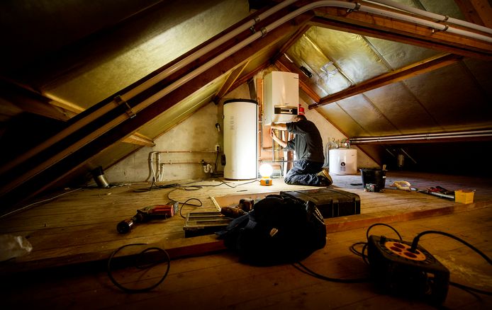 Een erkende installateur is bezig met het installeren van een warmtepomp bij een verwarmingsketel, als onderdeel van een project om een jaren-60 woning energiezuinig te maken. Er vallen steeds meer slachtoffers door het verkeerd installeren of slecht onderhouden van cv-ketels, vaak door onbekwame, niet-erkende installateurs.