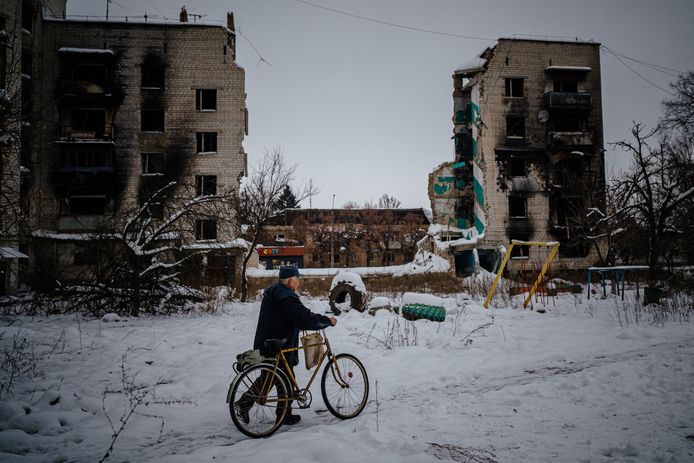 Een inwoner van Borodjanka, een voorstad van Kiev, wandelt voorbij een kapotgeschoten appartement.