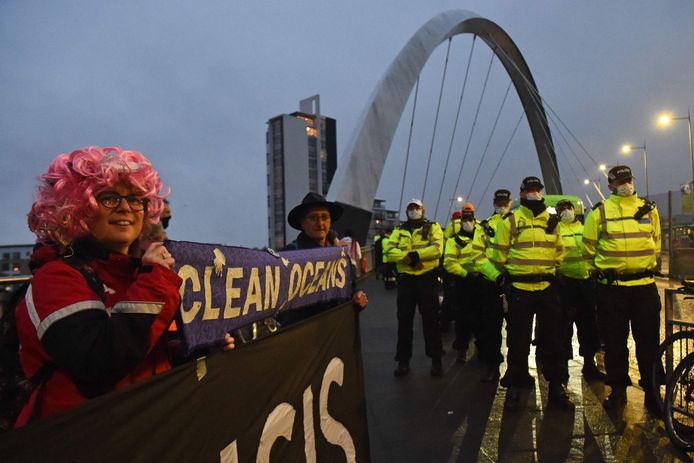 Politieagenten houden de wacht terwijl actiegroepen betogen in de wijk Maryhill, in de Schotse stad Glasgow.