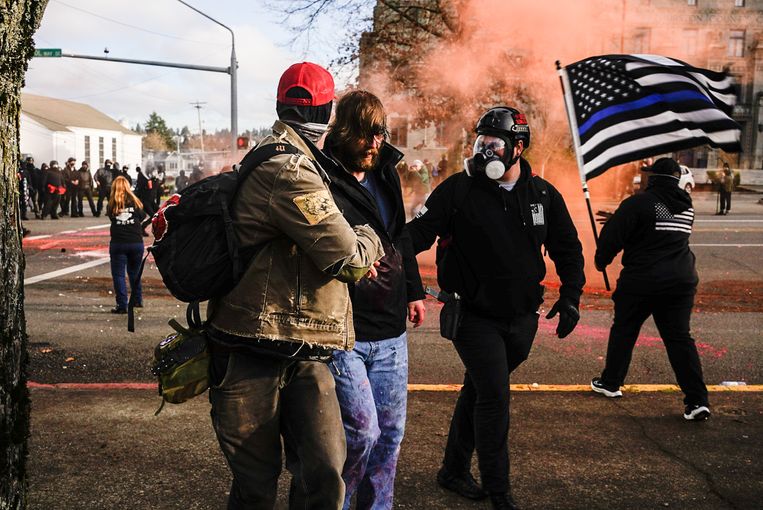 Demonstranten helpen een Trump-supporter die gewond raakte tijdens de protesten in Olympia (Washington).  Beeld Getty Images