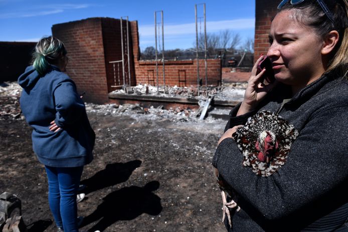 Een inwoner van Eastland County houdt een kop vast terwijl ze naast een afgebrand huis staat. (18/03/2022)