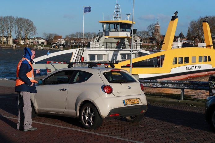 Automobilisten worden op de veerstoep in Groot-Ammers door verkeersregelaars teruggestuurd omdat een van de twee veren donderdag tijdens de storm lek sloeg.