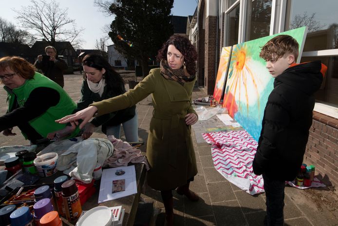 Een jonge Boskampenaar werkt mee aan het dorpsschilderij over het hart van de Boskamp.