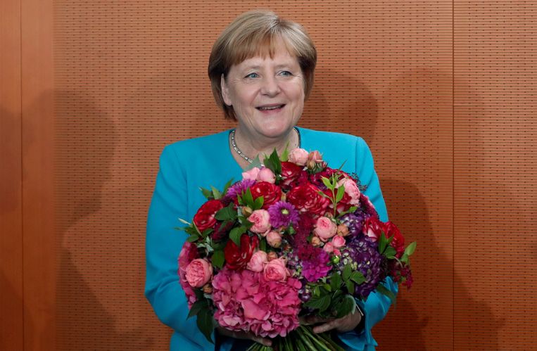 Angela Merkel krijgt bloemen op haar 65-ste verjaardag, vorige week.  Beeld REUTERS